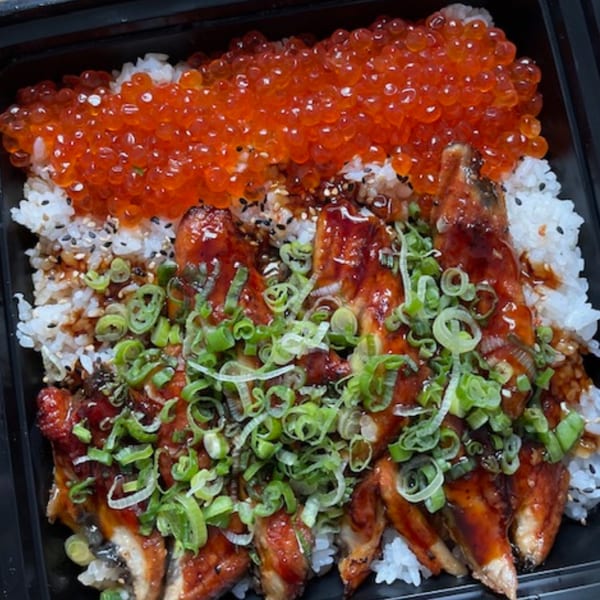 Unagi donburi with grilled eel, bright orange salmon roe, and chopped green onions over white rice.